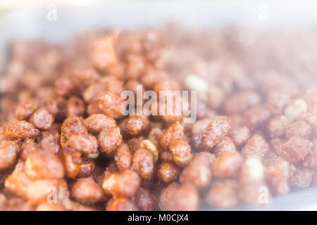 Macro closeup di fritto arrosto dadi rivestiti brown arachidi mandorle in NYC New York Street food carrello Foto Stock