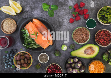 Con pesce fresco e salutare gli ingredienti alimentari con semi, legumi, frutta e verdura. Vista dall'alto, uno spazio vuoto, superficie rustico Foto Stock