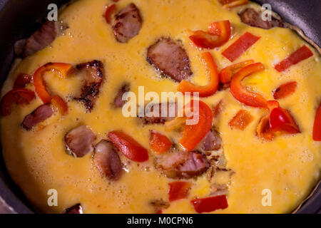 Uova strapazzate con prosciutto e verdure in una padella Foto Stock