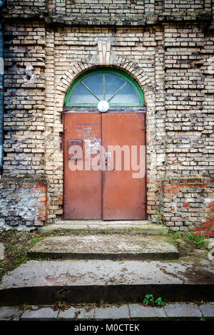 Vecchie porte e gradini di metallo nella parete di strada Foto Stock