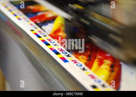 Plotter a Getto di inchiostro della testa di stampa si spostano nel marchio CMYK su carta bianca. Digitale grande macchina stampante. Foto Stock