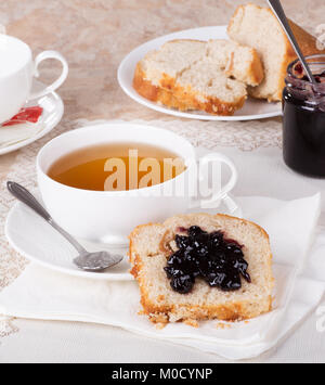 Pane dolce con confettura di mirtilli e una tazza di tè Foto Stock