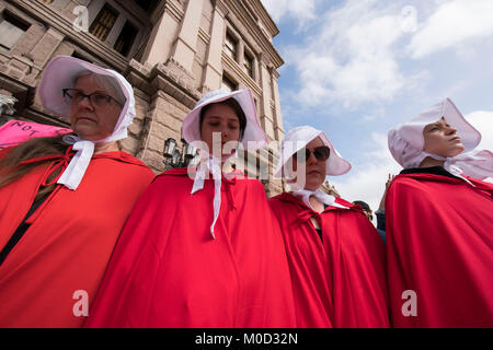 Donne abbigliate come caratteri da Margaret Atwood il libro "Una serva del racconto' di partecipare a un raduno al Campidoglio del Texas ad Austin per commemorare il primo anniversario della donna marzo su Washington e politiche si oppongono emanata durante il presidente Donald Trump il primo anno in carica. Foto Stock