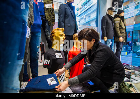 Salonicco, Grecia - 19 Gennaio 2018: Donna decora la finestra alla vetrina di un negozio di abbigliamento nel centro di Salonicco in vista dell'inverno sconti Foto Stock