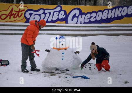 Famiglia scolpisce un pupazzo di neve durante la Battaglia di arte di pupazzi di neve vicino al palazzo di pionieri sulle colline Vorobievy a Mosca, Russia Foto Stock