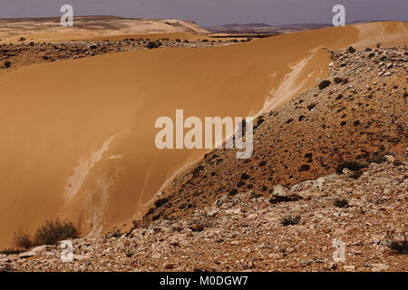 Guardando attraverso le rocce e dune di sabbia su un deserto marocchino Foto Stock