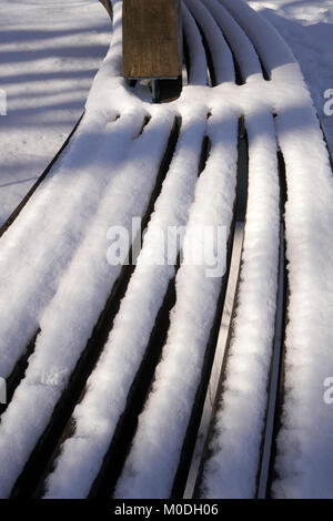 L'accumulo di neve su reti a doghe a banco di legno Foto Stock