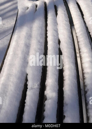 L'accumulo di neve su reti a doghe a banco di legno Foto Stock