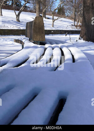 L'accumulo di neve su reti a doghe a banco di legno Foto Stock