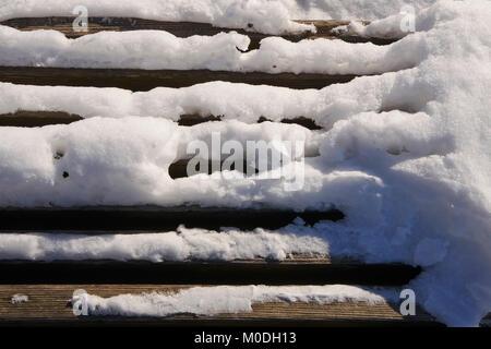 L'accumulo di neve su reti a doghe a banco di legno Foto Stock