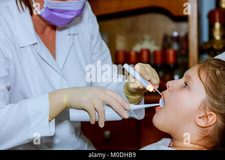 Ragazza sorridente in poltrona del dentista. bambino bocca spalancata sulla poltrona del dentista bambina al dentista Foto Stock