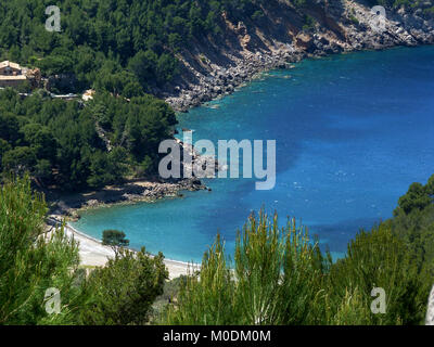 Maiorca, isole Baleari, una baia nascosta tra rocce ricoperte di macchia mediterranea in primavera Foto Stock