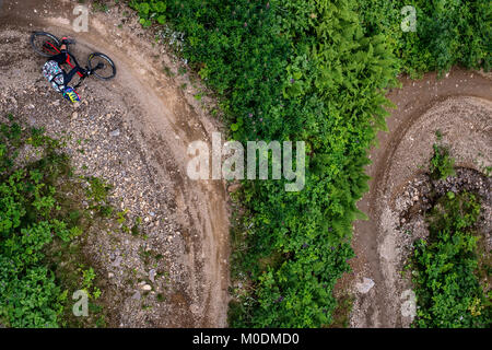 Un mountain biker cavalca un giro a Chatel Bikepark nelle Alpi francesi. Presi direttamente dall'alto. Foto Stock