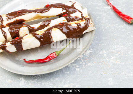 Pollo alla messicana enchiladas con peperoncino Salsa di cioccolato mole poblano. Tradiional cucina latino americana. Foto Stock