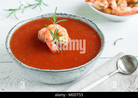 Vegetali zuppa di pomodoro gazpacho con gamberi (gamberetti) e rosmarino in ciotola di legno bianco sfondo, vista dall'alto, copia dello spazio. Foto Stock