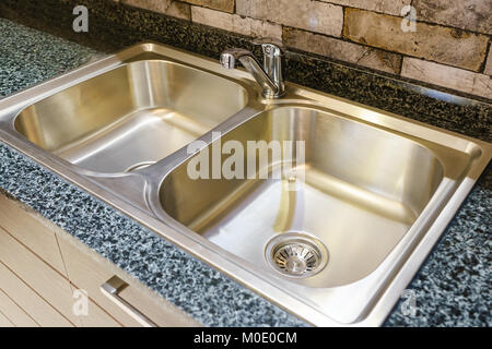Angolo di visione di lavello con rubinetto di argento in cucina, camera moderna contro con lavandino in camera con cucina, interior design concept Foto Stock