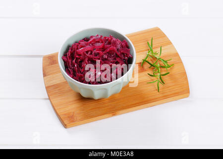 Ciotola di decapare cavolo rosso sul tagliere di legno Foto Stock