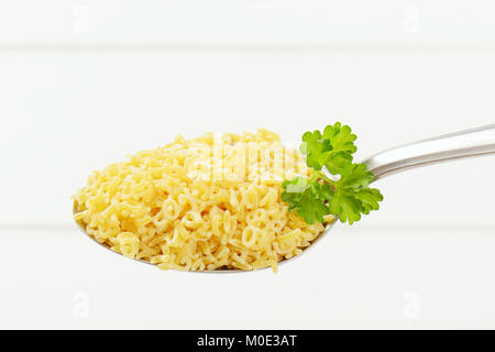 Cucchiaio di alfabeto crudo pasta bianca su sfondo di legno Foto Stock