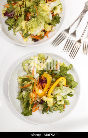 Fresca Insalata estiva con giallo paprika e strisce di carota su una piastra bianca Foto Stock