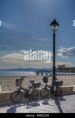 Immagine hdr di biciclette contro la parete di ritegno sulla passeggiata dalla spiaggia sabbiosa a Los Alcazares in Murcia Spagna Foto Stock