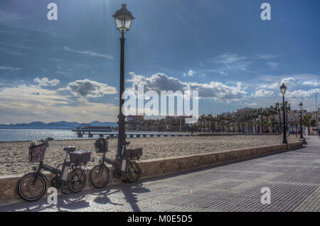 Immagine hdr di biciclette contro la parete di ritegno sulla passeggiata dalla spiaggia sabbiosa a Los Alcazares in Murcia Spagna Foto Stock