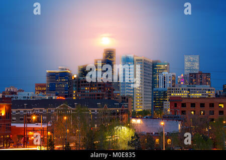 Denver Colorado colorato skyline di notte con incandescente luna piena al di sopra del centro di grattacieli al crepuscolo Foto Stock