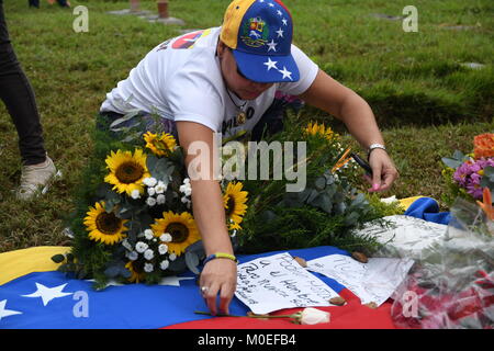 Caracas, Venezuela. Xxi gen, 2018. Un membro della famiglia mettere giù alcune note sulla tomba di Oscar Perez durante il funerale.Il corpo di Oscar Perez, ispettore di polizia scientifica, fu sepolto nel cimitero di orientale. Il funerale era sorvegliato da agenti della Guardia Nazionale e solo la zia potrebbe vedere il corpo e la testimonianza del funerale. Il cimitero è stato chiuso fino a 8:00 am quando la guardia nazionale ha deciso di ritirarsi e consentire l'accesso al pubblico. La società civile e i membri della famiglia pagato rispetto alla tomba dell'ispettore. Credito: Roman Camacho/SOPA/ZUMA filo/Alamy Live News Foto Stock