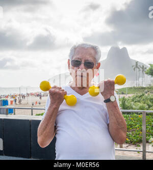 Modello rilasciato: uomo vecchio (80-89) esercizio utilizzando i pesi in palestra pubblica a Ipanema, Rio de Janeiro, Brasile Foto Stock