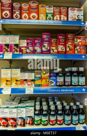 Farmaci contro la tosse e bambini antidolorifici (analgesici) su un ripiano di farmacia in una farmacia inglese. Foto Stock