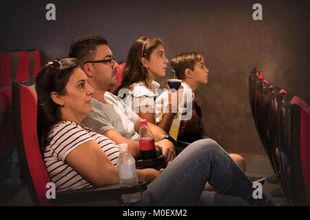 Famiglia seduti in un cinema a guardare un film Foto Stock