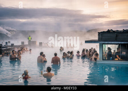 BLUE LAGOON, penisola di Reykjanes, Islanda. La folla di turisti e persone di balneazione e gustare drinks nelle calde acque del bagno geotermico resort Foto Stock