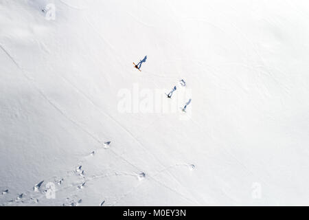 Vista aerea di tre sciatori e le loro ombre nelle Alpi, Sportgastein, Salisburgo, Austria Foto Stock