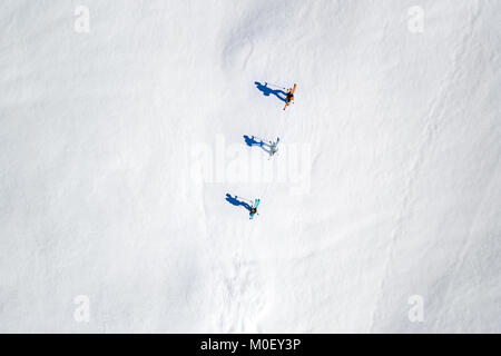 Vista aerea di tre sciatori e le loro ombre nelle Alpi, Sportgastein, Salisburgo, Austria Foto Stock