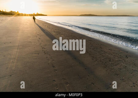 Il camminatore solitario al tramonto, Alki Beach, Seattle, Washington, Stati Uniti d'America Foto Stock