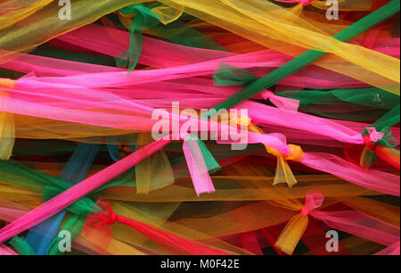 Strisce di colori diversi nastri di tessuto decorare un bodhi tree al tempio in Thailandia Foto Stock