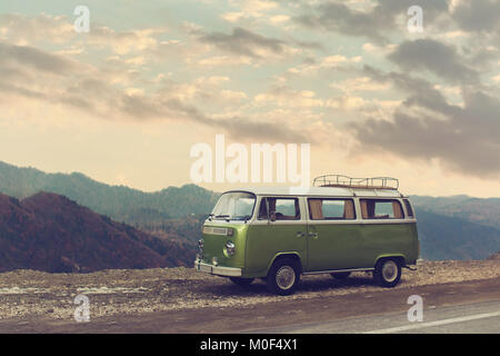 Classico verde Vintage camper parcheggiato sulla strada sotto le nuvole. Foto Stock