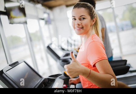 Giovane donna attraente facendo cardio-training in palestra Foto Stock