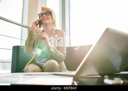 Telefono di conduzione di negoziati con i partner aziendali Foto Stock