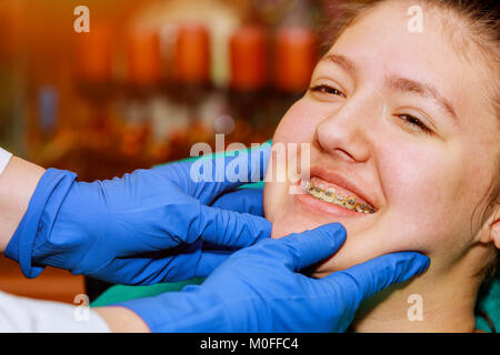 Un intervento di chirurgia dentale o bretelle di trattamento è fatto dentista ortodontista e concetto. Donna sorridente che mostra i suoi denti bianchi Foto Stock