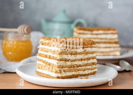 Miele torta stratificata o torta russa Medovik sulla piastra bianca. Vista ingrandita, il fuoco selettivo Foto Stock
