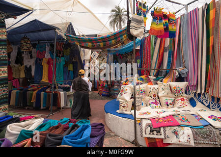 Otavalo, Ecuador - 13 Gennaio 2018: un fornitore di indigeni si erge nel mercato artigianale Foto Stock