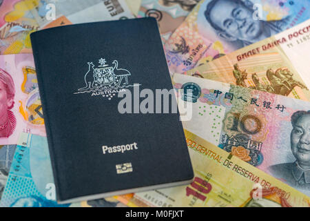 Australian Travel Passport giacente sulla parte superiore della carta moneta da diversi paesi Foto Stock