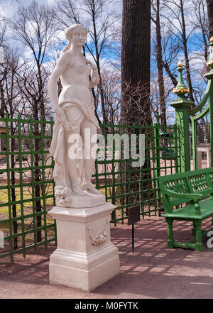 Statua di una ninfa in un parco giardino estivo vicino a green grid per il supporto di impianti in aprile a inizio primavera prima dell'inizio dell'estate stagione del parco in S Foto Stock