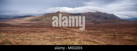 Il Cloud rotoli Beinn Spionnaidh montagna vicino a Durness nel tetro e paesaggio arido del telecomando lontano Nord delle Highlands della Scozia. Foto Stock