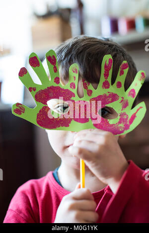 Ritratto di un 6 anno vecchio ragazzo con una maschera di Carnevale da lui stesso realizzato a casa Foto Stock