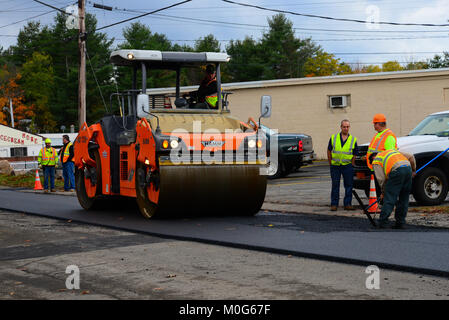 Un equipaggio di strada e apparecchiature resurfacing una strada speculatore, NY USA Foto Stock