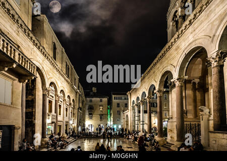 Il peristilio del Palazzo di Diocleziano a tarda notte sotto una luna piena di turisti che si godono le rovine romane in Split Croazia Foto Stock