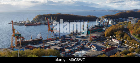 Penisola di Kamchatka panorama sulle navi al molo, gru portuali sul porto commerciale Petropavlovsk-Kamchatsky città sulle rive della Baia Avacha in Oceano Pacifico Foto Stock