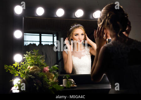 Ritratto di giovane sposa vicino a specchio vista posteriore. Brides mattina Foto Stock