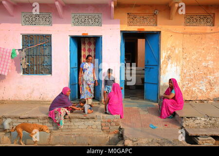 CHITTORGARH, Rajasthan, India - 14 dicembre 2017: scene di strada con le donne e i bambini di fronte a loro tradizionale e casa colorati Foto Stock